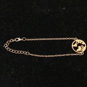 Gold tone bracelet with world map